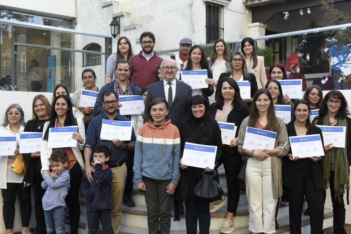 Personas paradas con certificados en mano.