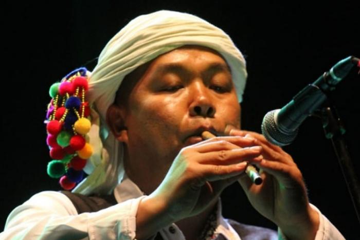 Artista chino con ropa festiva tocando la flauta Artista chino con ropa festiva tocando la flauta