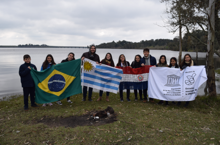 Personas con las banderas de Brasil, Uruguay, Paraguay y UNESCO