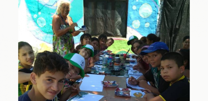 El grupo de adolescentes de muralismo junto a la tallerista sonriendo