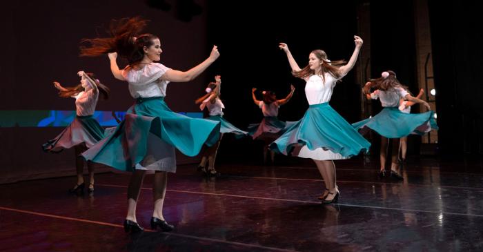 Mujeres en escenario bailando folclore