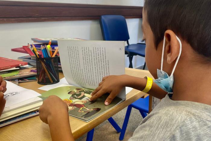 niño en mesa con libro