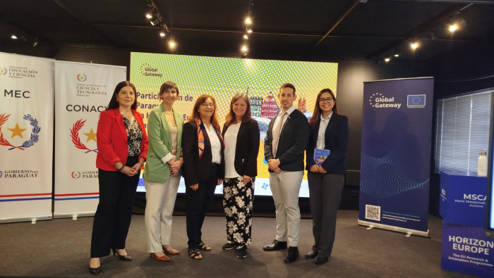 Seis personas posan de pie frente a un cartel del programa Horizonte Europa y banners 