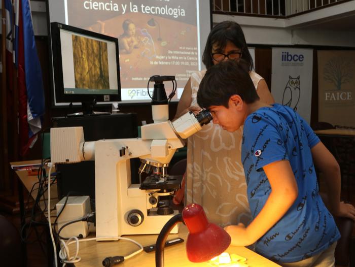 Un participante del taller de microscopía "Los ojos de ella" mira por un microscopio.
