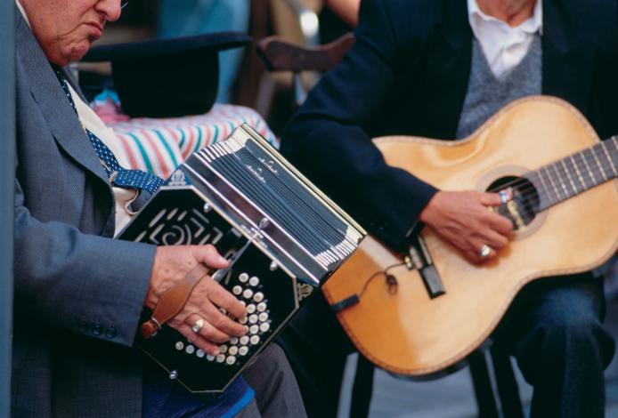 Dos hombres sentados con una guitarra y un bandonéon