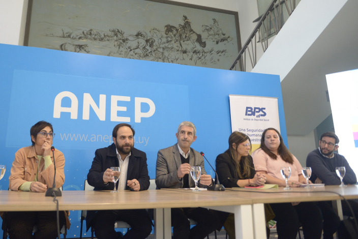 Personas en mesa durante conferencia.