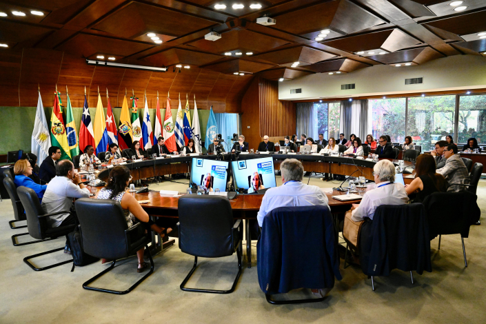 Sala de reuniones con las delegaciones, al fondo banderas de los países