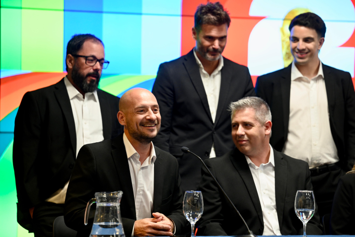 Personas en mesa hablan al público