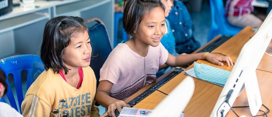 Niñas asiáticas frente a una computadora