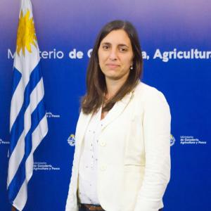 Foto oficial de la Directora de DIGEBIA junto al pabellón uruguayo.