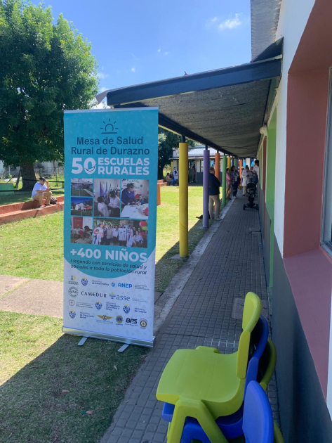 Banner de Mesa de Salud Rural de Durazno Foto del patio de la escuela con banner de la Mesa de Salud Rural de Durazno