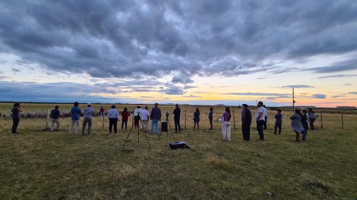 Personas en el predio al atardecer