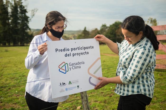 Ximena y Laura colocando cartel