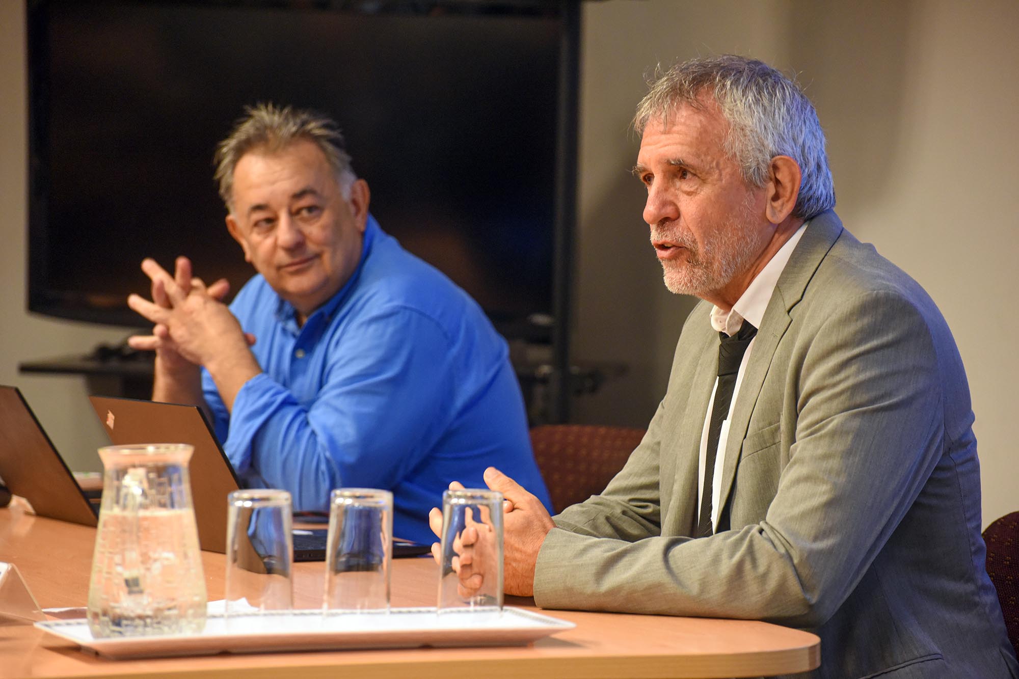 Dos hombres frente a una mesa