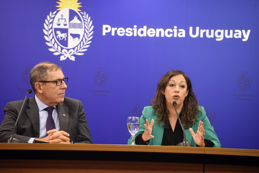 Cardona habla junto a Oddone; detrás, banner con logo de Presidencia