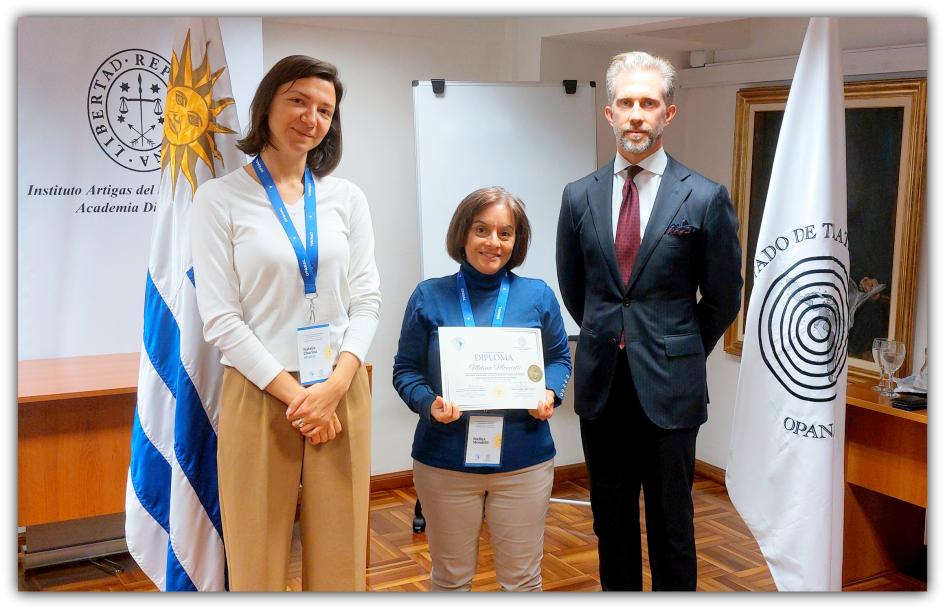 Entrega de certificado Melina Mondelli, recibiendo su certificado de asistencia junto a los expertos de OPANAL