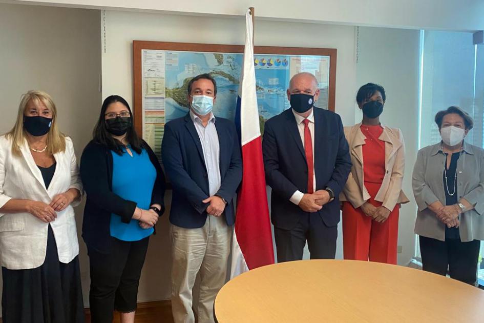 Delegaciones de Uruguay y Panamá; detrás hay una bandera de Panamá y un cuadro; delante, una mesa