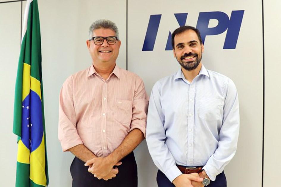 El director Santiago Martínez lideró la visita a Brasil Director Santiago Martínez, junto a otro hombre, sonríen junto a una bandera de Brasil
