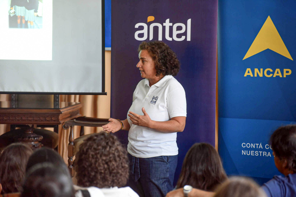Blanca Gómez, de Latitud Mujer habla frente a niñas, niños y adolescentes sentados