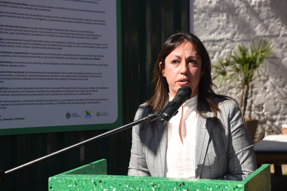 Ministra Fernanda Cardona habla desde un atril; detrás, cartel.