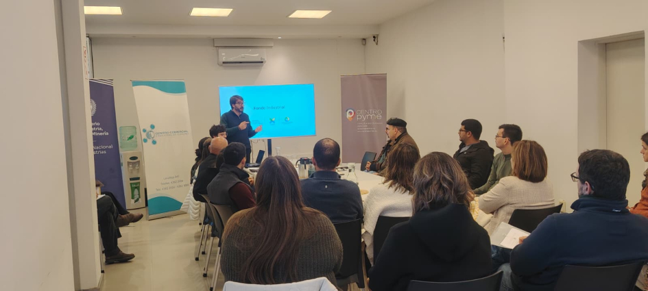 Director Míguez, de pie, en el taller de Durazno; frente a él, público, sentado