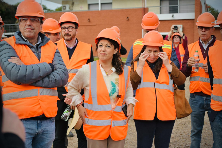 Cardona y otras personas visten cascos y chalecos naranjas en un espacio exterior
