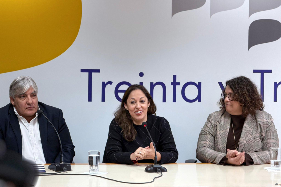 Ministra Fernanda Cardona, junto a Alejandro Paz (Antel) y Beatriz Martínez (Accesa) Cardona habla junto a Paz y Martínez; detrás, banner
