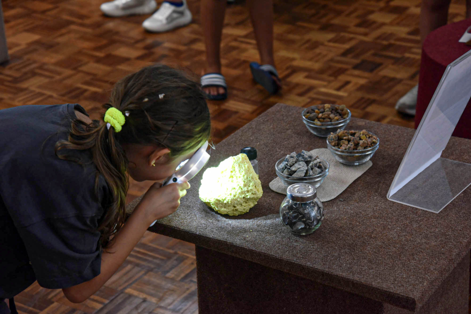 Actividad en el Museo Geominero Niña observando una piedra de cerca con una lupa