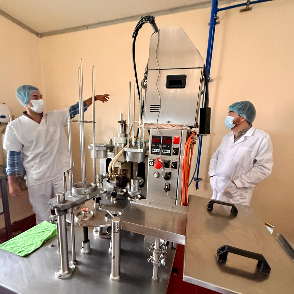 Personas con túnicas y tapabocas en planta industrial