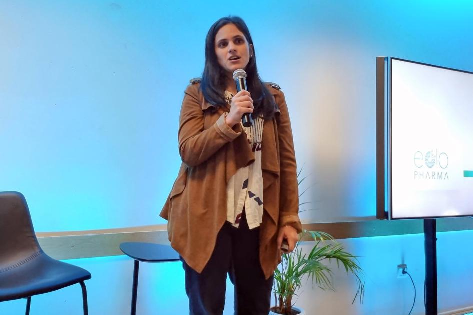 Pía Garat, de Eolo Pharma Una mujer habla; a sus lados, una pantalla y una silla