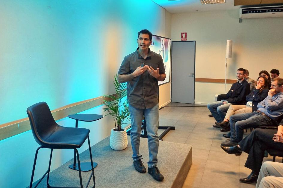 Matías Machado, de Scaffold Biotech Un hombre habla sobre un escenario; a su lado, una silla; enfrente, el público