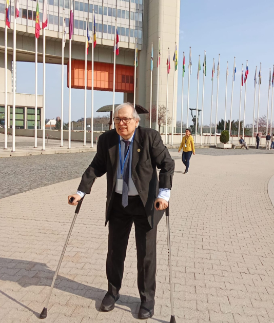 Humberto Piano en la sede del OIEA; es un espacio abierto; detrás, banderas