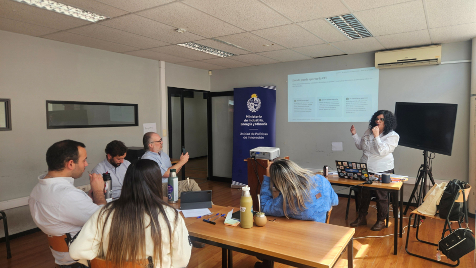 Presentación de la consultora Silvina Papagno en Paysandú Personas sentadas; al fondo, una de pie y una pantalla