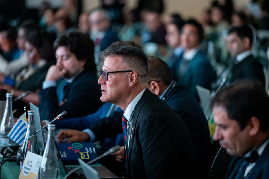 Siris habla, sentado junto a muchas otras personas