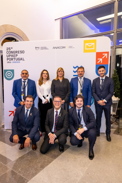 Grupo de personas de pie y en cuclillas; detrás, banner del evento