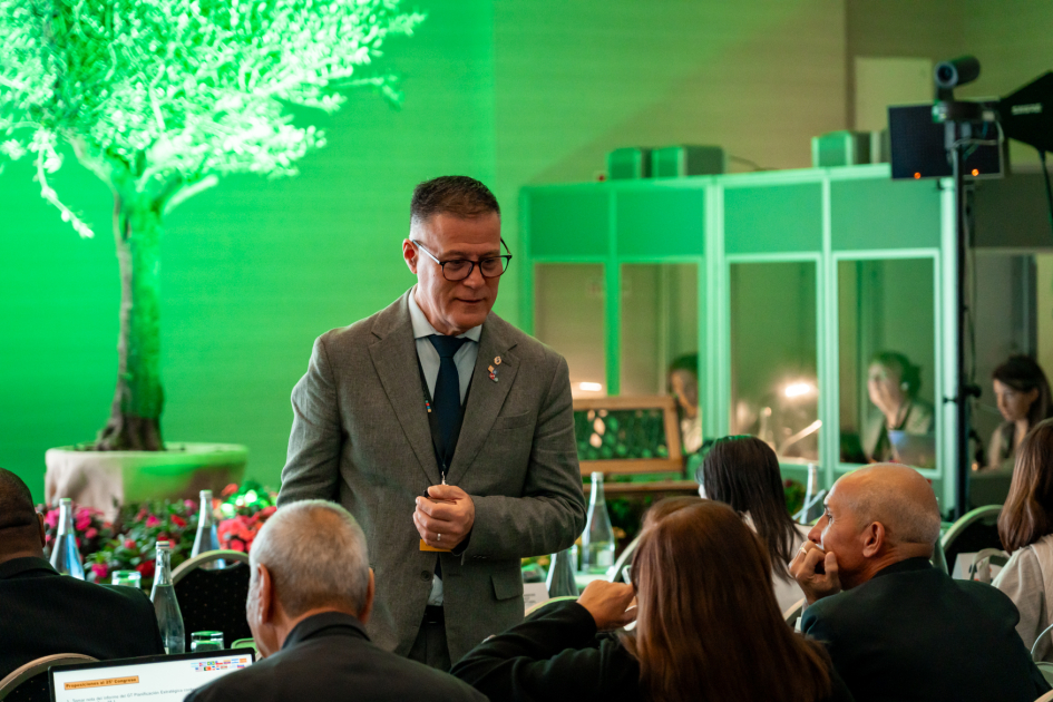 Siris, de pie, ante un grupo de personas sentadas