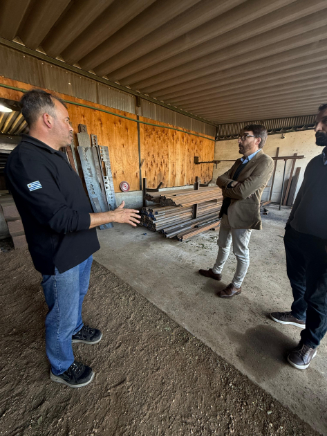 Director nacional de Industrias visitó la empresa Trailersuy Míguez y otras personas, de pie en la planta