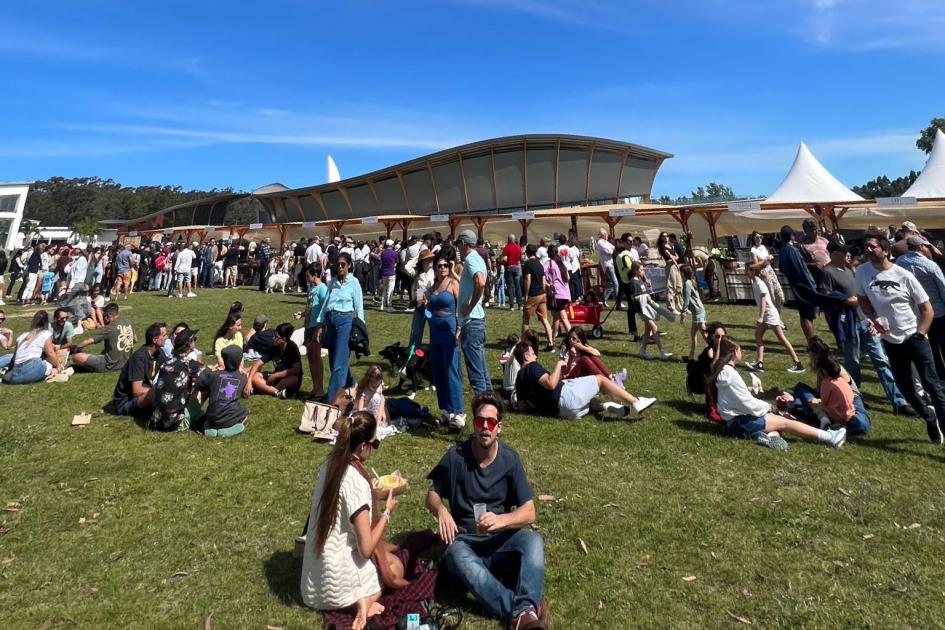  Gente al aire libre en un día de sol, en el exterior del MACA, que se ve al fondo