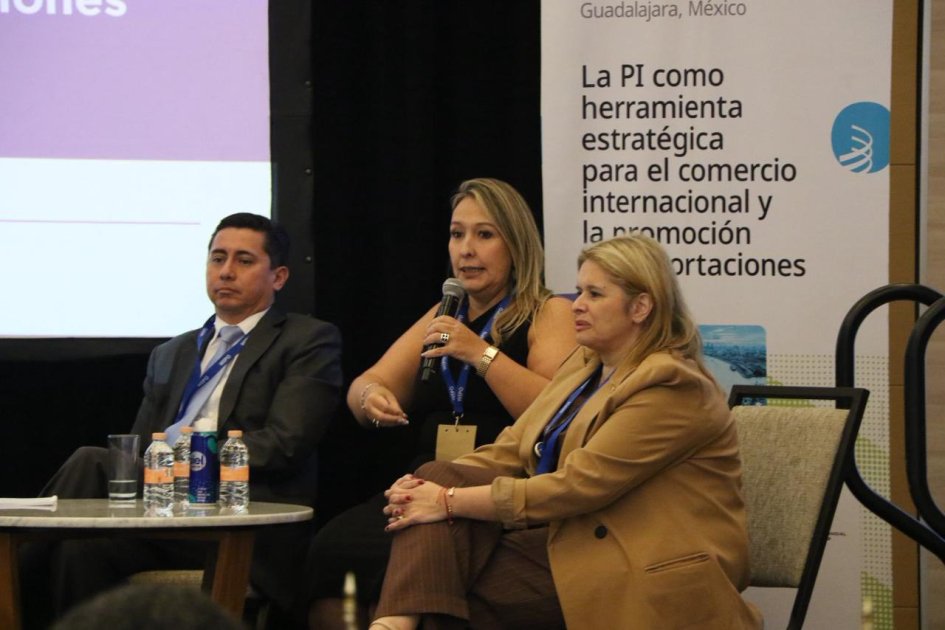 Tres personas sentadas en una mesa; una habla