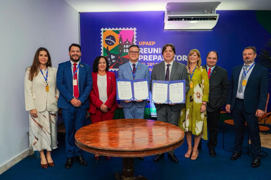Ministro y director muestran los documentos, de pie junto a otras personas