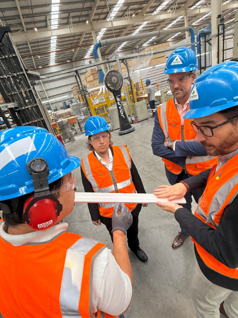 Varias personas visten cascos y chalecos en el interior de la empresa