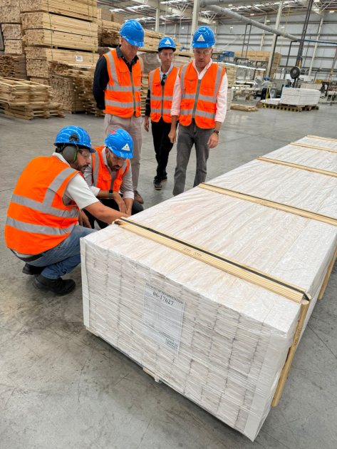 Personas con cascos y chalecos observan producción dentro de la empresa
