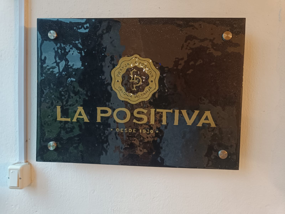 Cartel negro de La Positiva colgado en pared