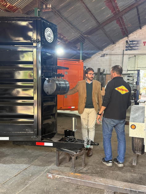 Director nacional de Industrias visitó la empresa Trailersuy Míguez dialoga con una persona; al lado, tráiler