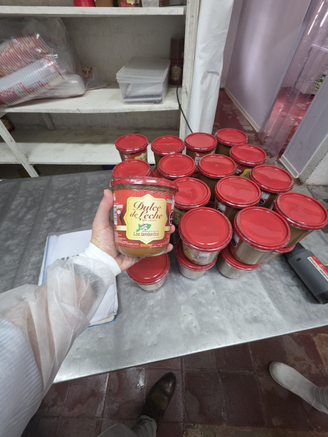 Mano sostiene un tarro de dulce de leche