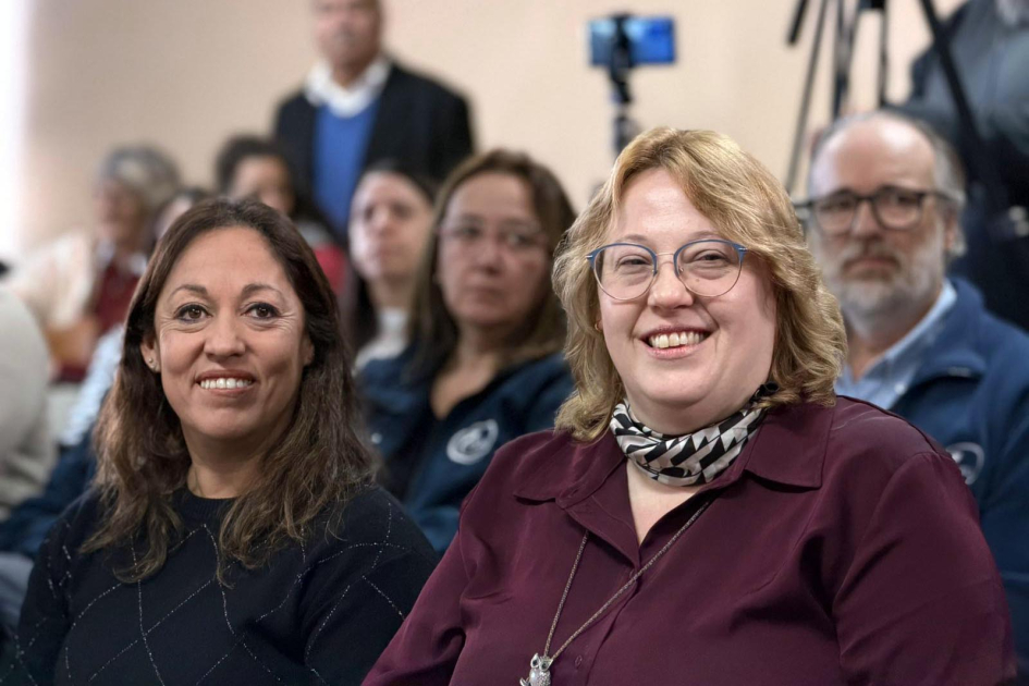 Ministra Fernanda Cardona y directora de Dinapyme, Ximena Cidrás Cardona sonríe junto a Cidrás; detrás, otras personas en el público