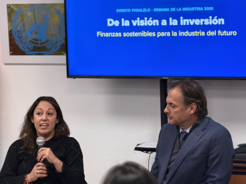 Habla Cardona; a su lado, Pettinato; arriba, pantalla con el nombre del evento