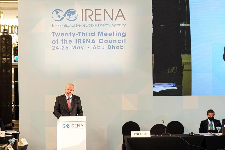 Verri hizo un discurso al presidir la sesión Verri habla desde un atril; detrás hay un banner de IRENA y al lado una mesa con un hombre