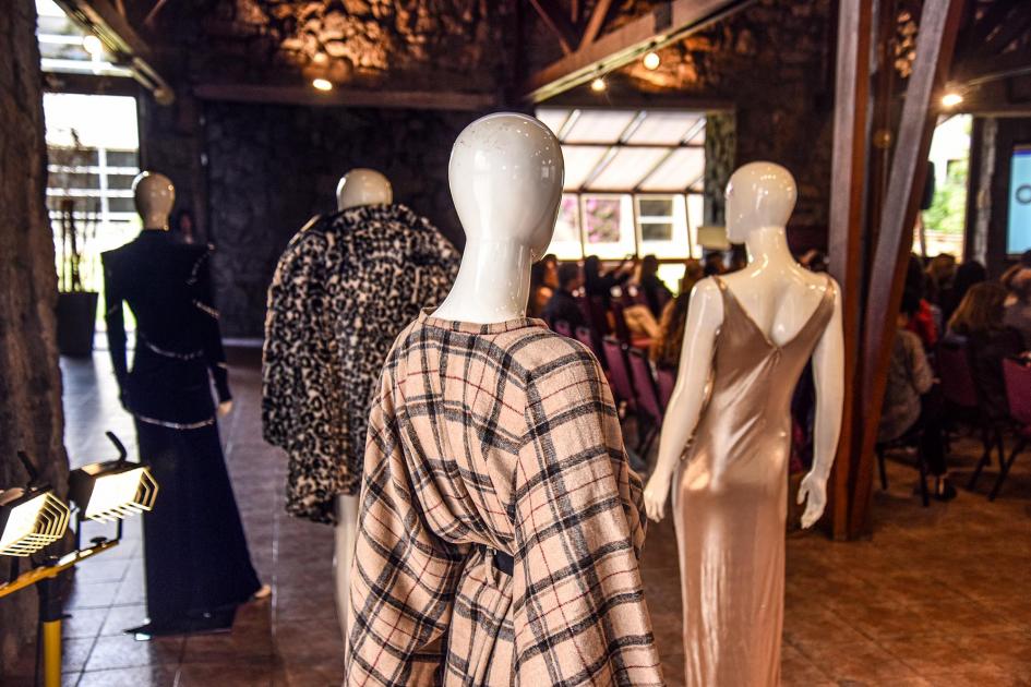 Moda exhibida durante el evento Vestidos exhibidos; se ven de espaldas; los primeros son de colores en la gama del marrón