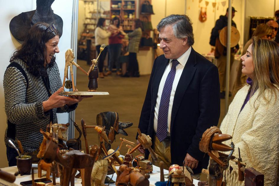 Paganini conversa con una artesana en el stand de Artesanía Uruguay.